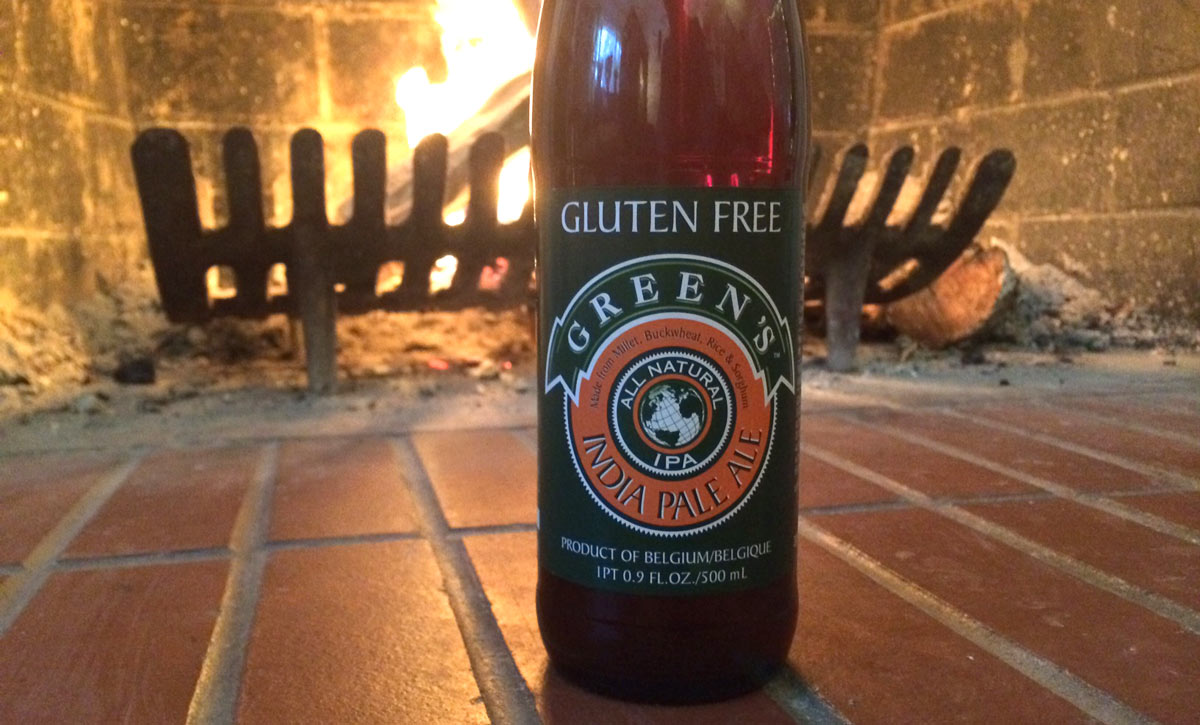 Bottle off Greens's IPA in front of a Fireplace